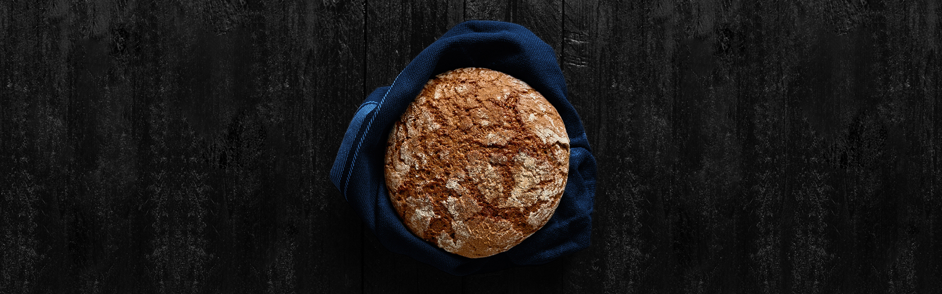 Freshly baked bread on black wooden background. Top view. Copy space.