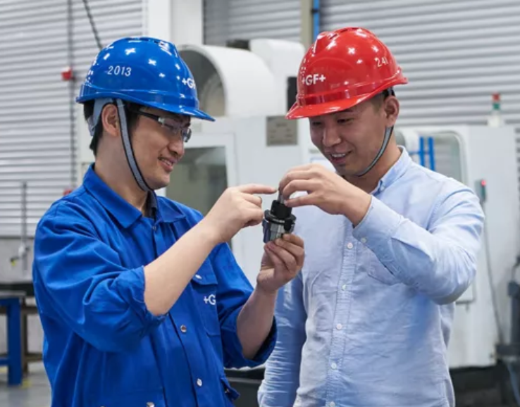 Kaksi hymyilevää miestä GF-kypärissä